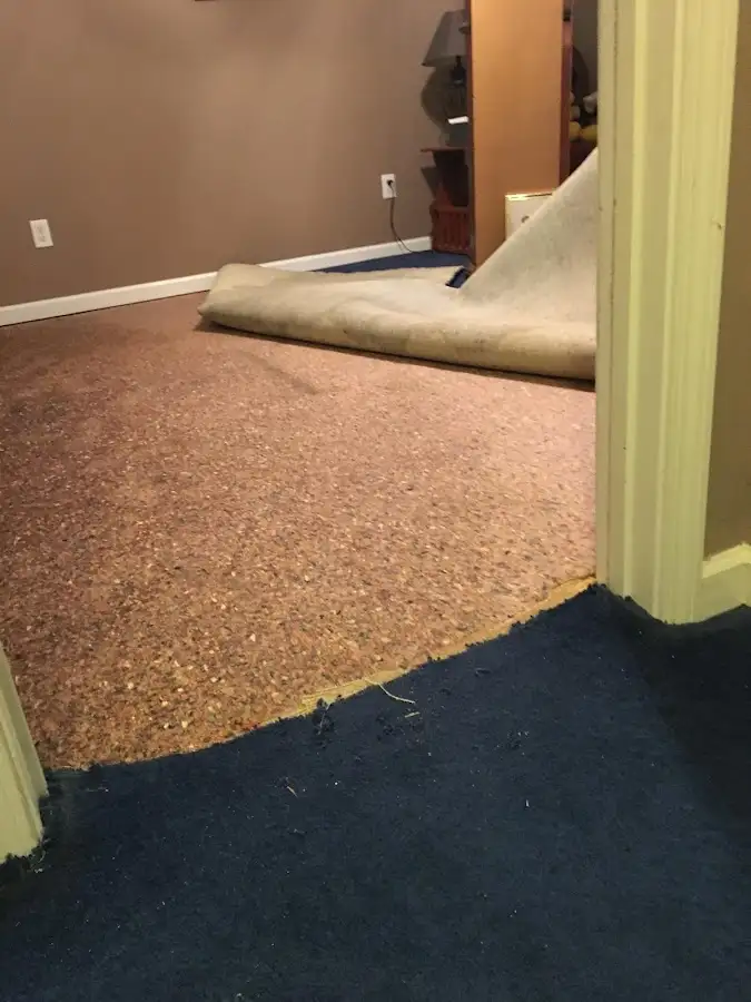 Carpet pad removal revealing water damage during Drying & Dehumidification in Sioux Center